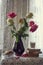 A bouquet of roses in a ceramic vase . Next to it are books , a glass of milk, and a bowl of cookies