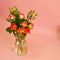 A bouquet of  roses in glass vase on  pink background