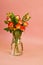 A bouquet of  roses in glass vase on  pink background