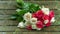 Bouquet of roses, white and pink, thrown over the wooden bridge to the lake on a rainy day