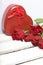 A bouquet of scarlet roses and a gift in a box in the shape of a heart.