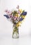 Bouquet of seasonal spring flowers. Sprigs of blossoming cherry, apricot, forsythia and muscari in a glass vase on a