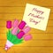 Bouquet of seven pink tulips, a sticker with text on the background of a wood texture. Congratulations. Mothers Day.