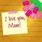 Bouquet of seven pink tulips, a sticker with text on the background of a wood texture. Congratulations. Mothers Day.