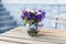 Bouquet of summer flowers in glass vase on table on terrace. Fresh Field flowers in vase. Cozy home decor of patio yard. Still lif