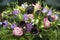 Bouquet summer flowers, pink roses, lilac lisanthus or eustoma, calla flowers, green leaves