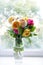 Bouquet of summer roses in glass vase near the window . flower background, greeting card