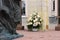 A bouquet of their cream roses and chrysanthemums at the sculpture of the kneeling figure of the Holy Prince Alexander Nevsky near