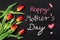 Bouquet of tulips and the sentence HAPPY MOTHER`S DAY written in chalk on a chalkboard