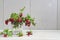 Bouquet of twigs with red ripe lingonberries in glass on light wooden background.