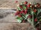 A bouquet of twigs of ripe wild strawberries with leaves on rustic wood background. copy space