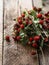 A bouquet of twigs of ripe wild strawberries with leaves on rustic wood background. copy space, selective focus