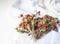 A bouquet of twigs of ripe wild strawberries with leaves on white kitchen napkin on table