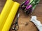 Bouquet of violet tulips on wooden table, scissors, yellow packaging paper and white lace. Bouquet making.