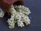 Bouquet of white flowers in a ceramic vase on the dark table.