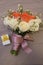 Bouquet of white and orange roses wrapped by purple satin bow
