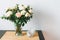 Bouquet of white and pink roses, greens and other flowers on table on kitchen, home decor