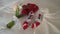 A bouquet of white and red flowers and woman shoes on a bed.