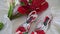 A bouquet of white and red flowers and woman shoes on a bed.