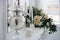 A bouquet of white roses, peonies, dahlias and eucalyptus branches and candles on the bedside table