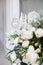 A bouquet of white roses, peonies, dahlias and eucalyptus branches and candles on the bedside table