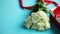 Bouquet of white roses with red bow on blue background. Boxed gift on side