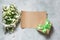 Bouquet white spring flowers with gift on light background. Top view. Copy space.