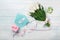 A bouquet of white tulips and a pink ribbon in the form of a heart with a gift box, love note and color envelope on blue wooden