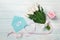 A bouquet of white tulips and a pink ribbon in the form of a heart with a gift box, love note and color envelope on blue wooden
