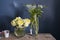 A bouquet of white veronica in a tall narrow vase on a grey table on the white background