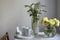 A bouquet of white veronica in a tall narrow vase on a grey table on the white background