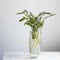 A bouquet of white veronica with white bells in a tall narrow vase on a grey table on the