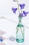 Bouquet of wild flower bellflower campanula  in a glass vase on an embroidered tablecloth, home decoration concept