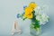 A bouquet of wild flowers, dandelions, pansies and cherry blossoms in a glass jar