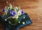 Bouquet of wildflowers from chamomile, cornflowers, spikelets of wheat in a glass vase on a wooden table