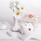 Bouquet of wildflowers white cosmos or cosmea in white vase, gift, white ceramic candlestick in the shape of apple