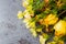 Bouquet of wilting flowers with yellow roses on a gray background close view