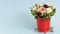 This is a bouquet of withering flowers in a decorative bucket on a blue background. Autumn time