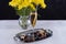 A bouquet of yellow chrysanthemum, a glass of champagne and a tray of chocolate