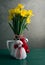 Bouquet of yellow daffodils tied with red-white martenitsa, martisor on a wooden table