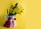 Bouquet of yellow daffodils tied with red-white martenitsa, martisor on yellow background