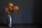 Bouquet of yellow and orange exotic protea flowers in a metal vase on a dark background, selective focus