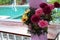 A bouquet of yellow, pink and red flowers placed on the balcony at the poolside.