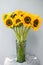 Bouquet of yellow sunflowers , flower in vase on old vintage table. Room morning. Gray background. Colors of autumn and