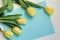 Bouquet of yellow tulips and blue lettering paper