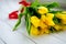 Bouquet of yellow tulips flowers on white wooden background. Waiting for spring. Happy Easter card, mother`s day, March 8. Flat