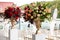 Bouquets of roses placed in vases for the deor on the wedding day. Outdoor ceremony.