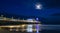 Bournemouth pier illuminated with lights under the moon