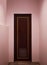 Boutique vintage retro wooden door made from plain tropical dark brown textured wood panel board with pink color painted wall back