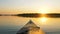 Bow of kayak floats on calm surface of twater at sunset in Golden hour, outdoor activities